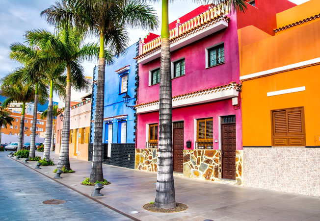 Tenerife. Colourful houses and palm trees on street in Puerto de la Cruz town